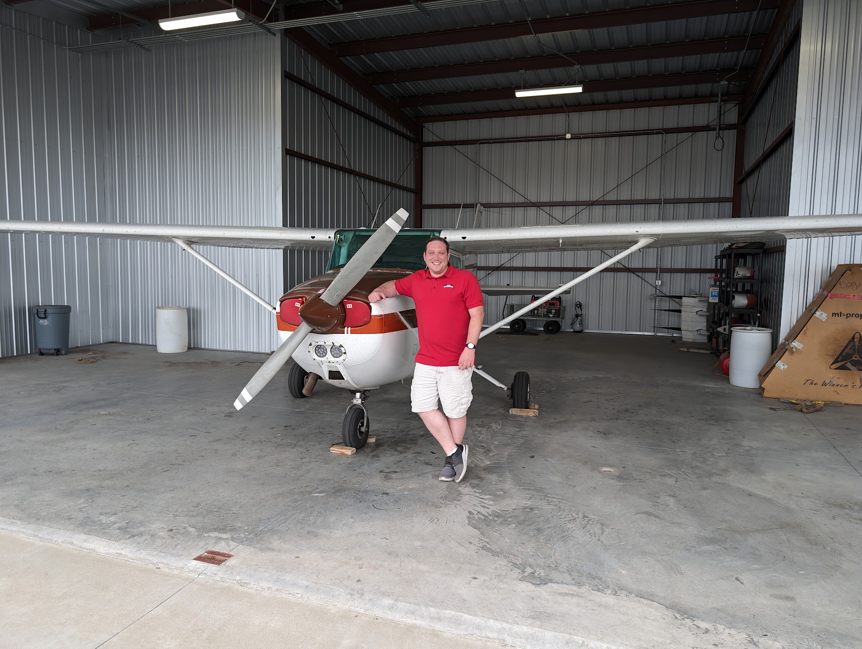 Brandon standing in front of a Cessna after passing the private pilot checkride